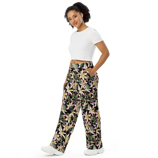 Black wide-leg lounge pants with colorful floral print and elastic waistband worn with white crop top.