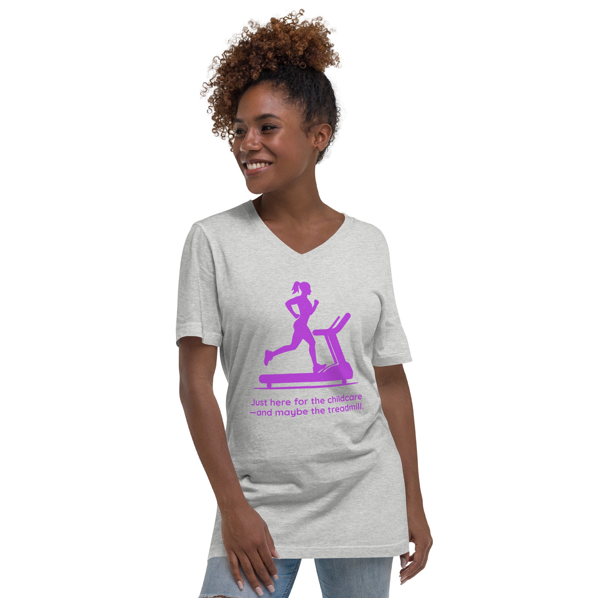 Light grey V-neck tee with purple graphic of a woman running on a treadmill and text "Just Here for the Childcare—and Maybe.