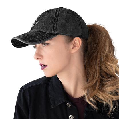 Black vintage cotton twill cap with white embroidered "Powered by Coffee, Chaos & Cardio" text worn with ponytail.