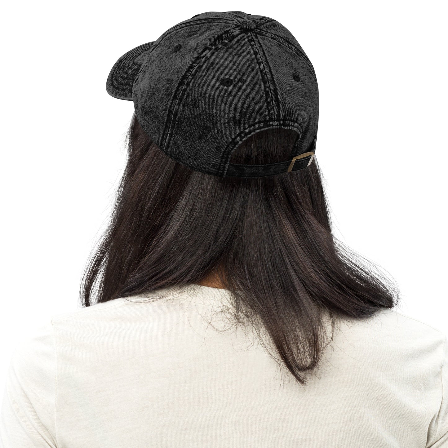 Black vintage cotton twill cap with adjustable strap worn by person with long dark hair, back view.