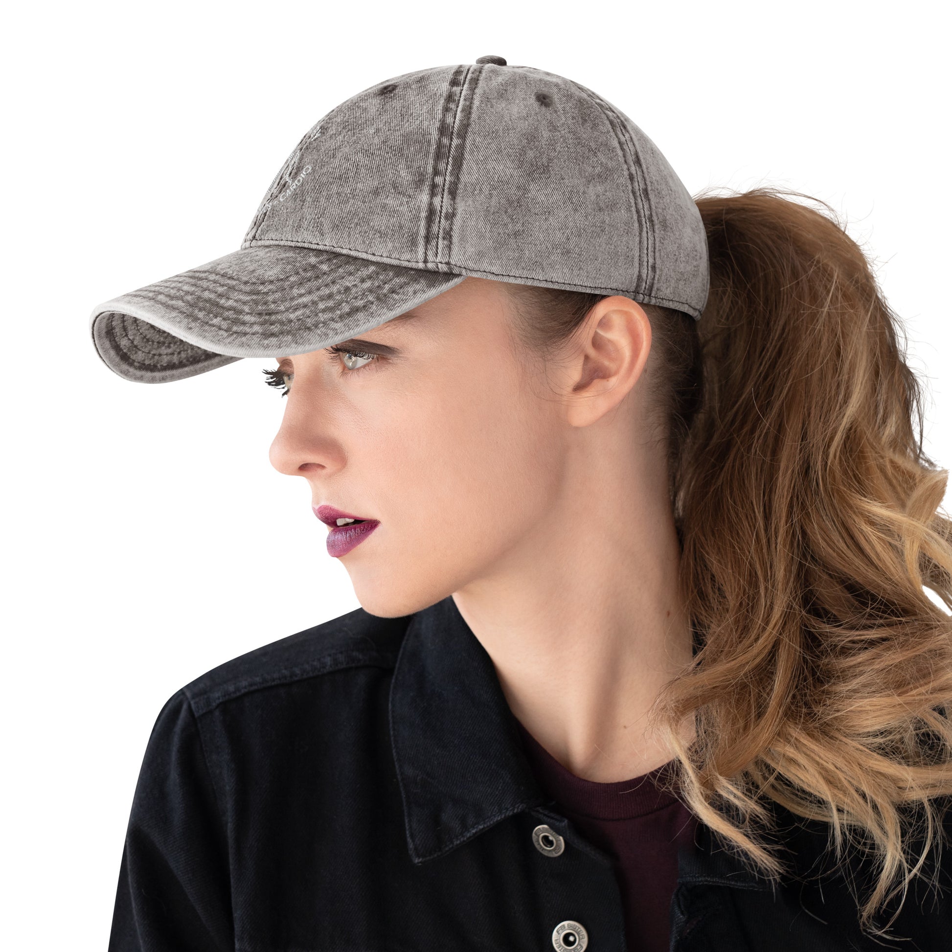 Charcoal grey vintage cotton twill cap with embroidered "Powered by Coffee, Chaos & Cardio" text worn with a ponytail.
