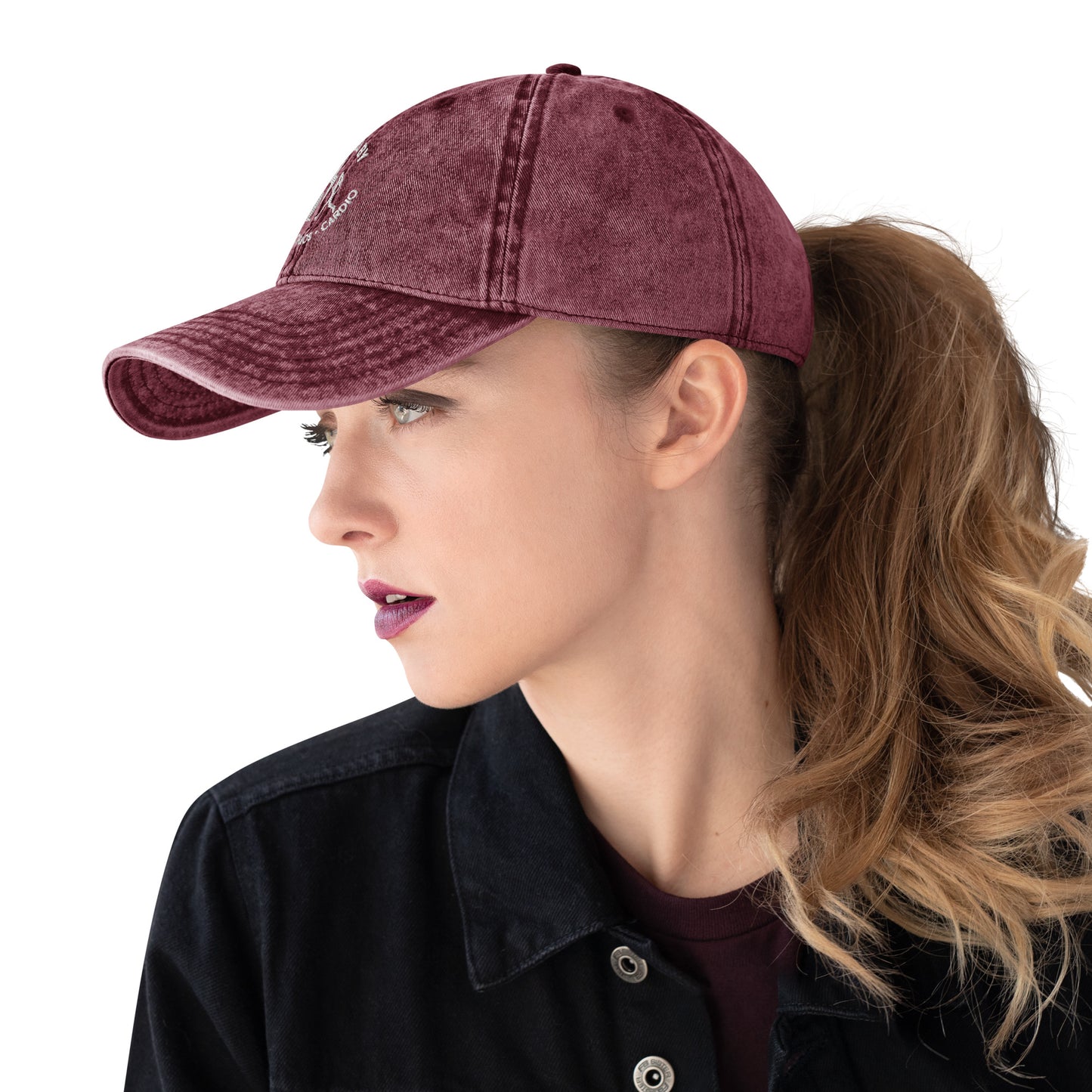 Maroon vintage cotton twill cap with white embroidered "Powered by Coffee, Chaos & Cardio" text, worn with ponytail.