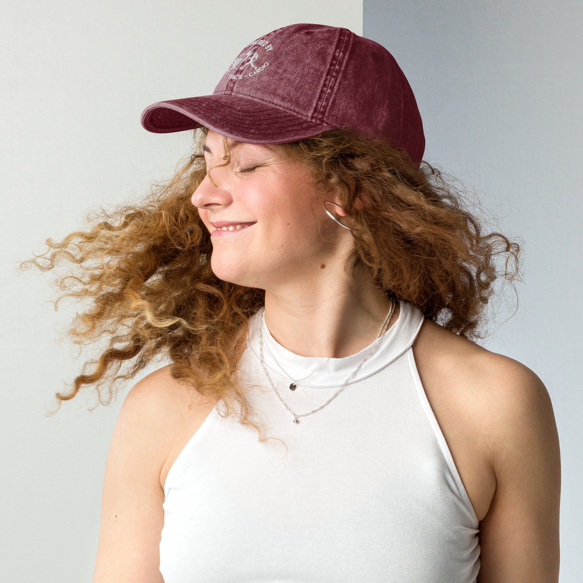 Maroon vintage cotton twill cap with curved brim and embroidered "Powered by Coffee, Chaos & Cardio" text worn by smiling.