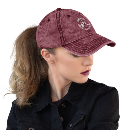 Maroon vintage cotton twill cap with white embroidered text and distressed finish worn with ponytail.