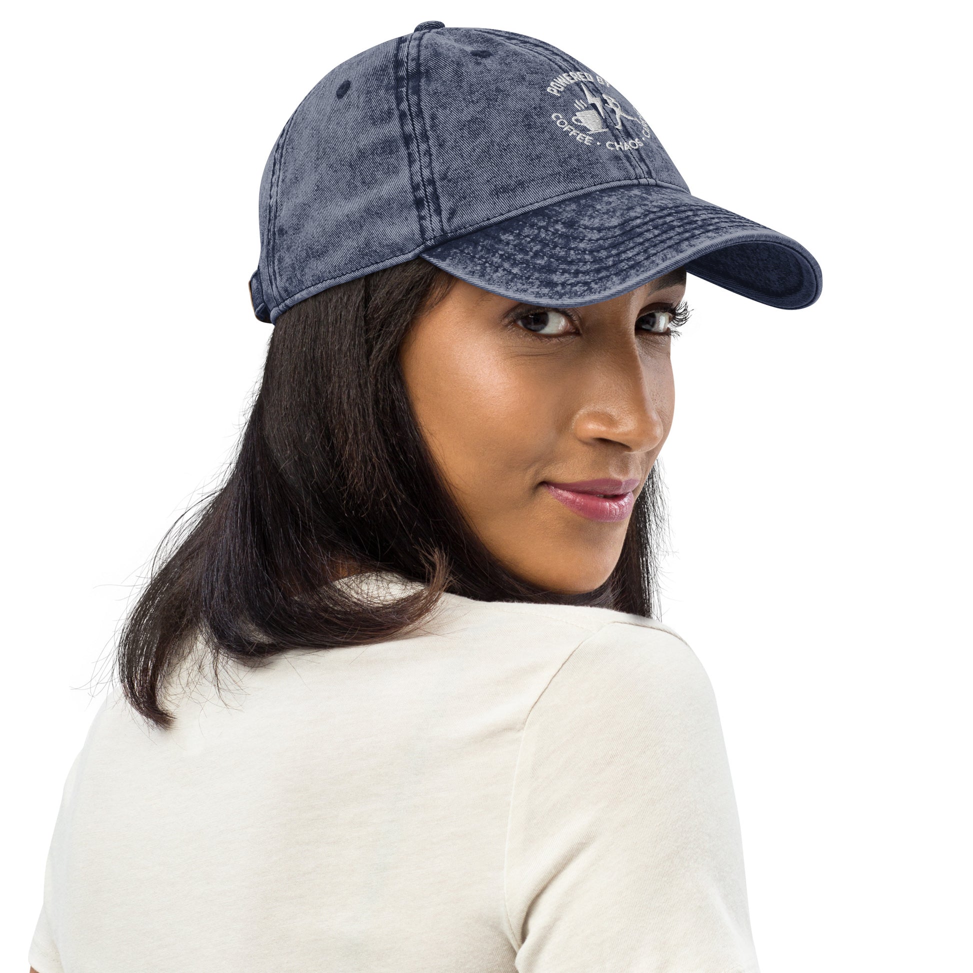 Charcoal grey vintage cotton twill cap with embroidered "Powered by Coffee, Chaos & Cardio" text, worn by woman.